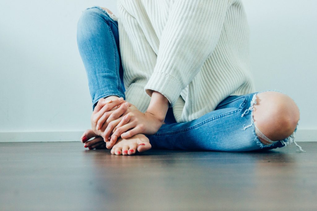 žena sedí na zemi a prožívá bolest z rozchodu