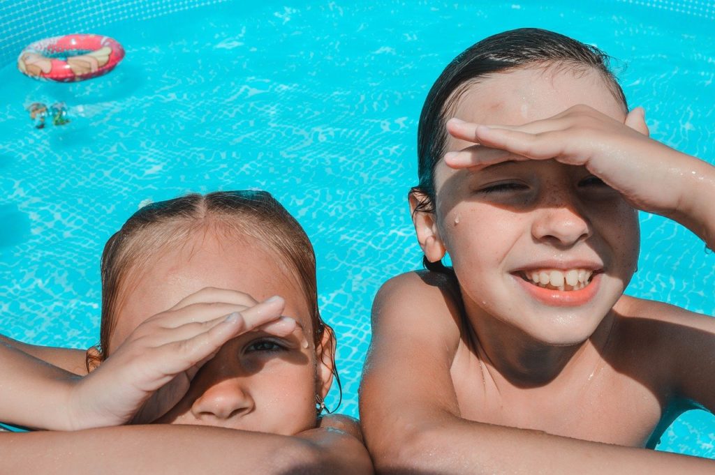 dvě dívky se v létě koupají v bazénu