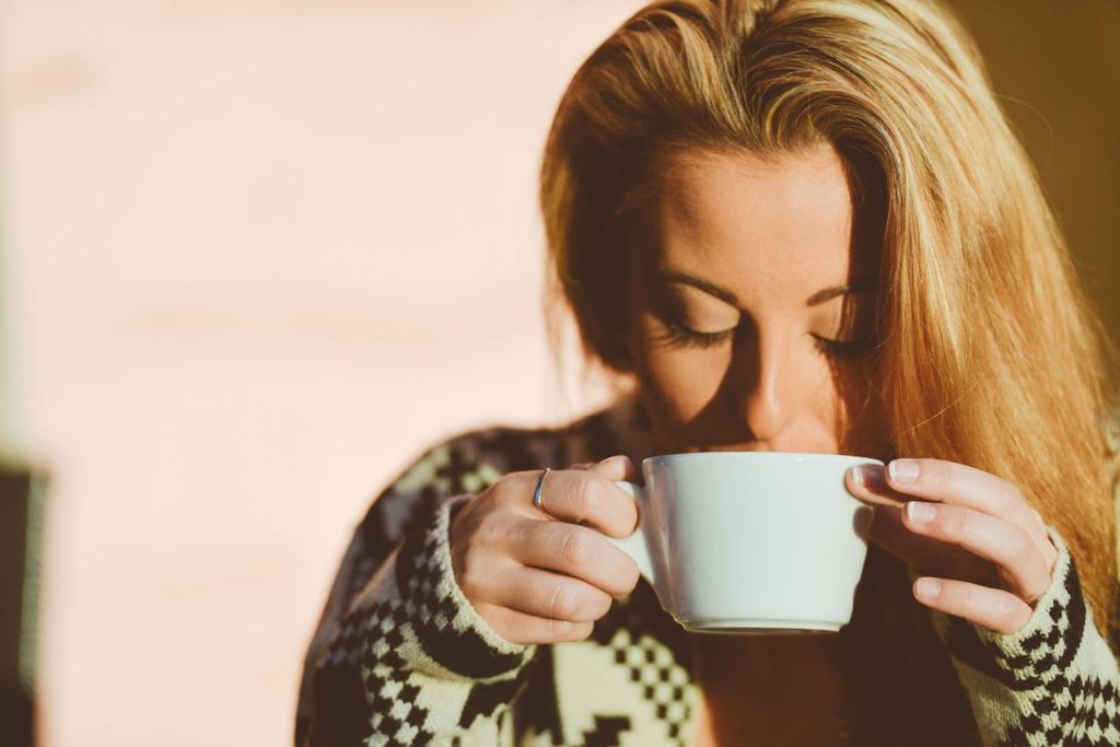 žena pije kávu z hrníčku