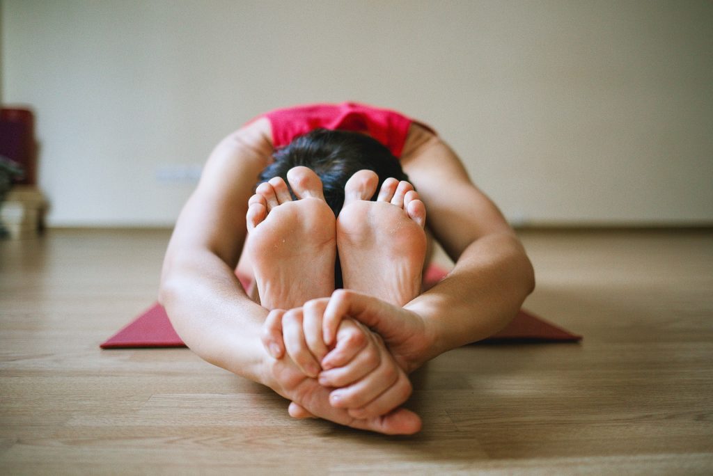 žena cvičící jógu na zemi